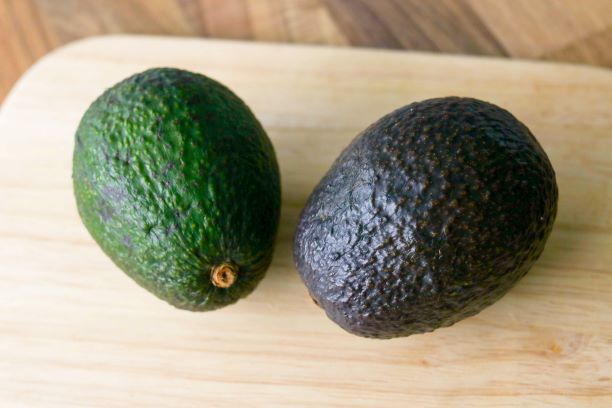 Kaksi eri väristä avokadoa