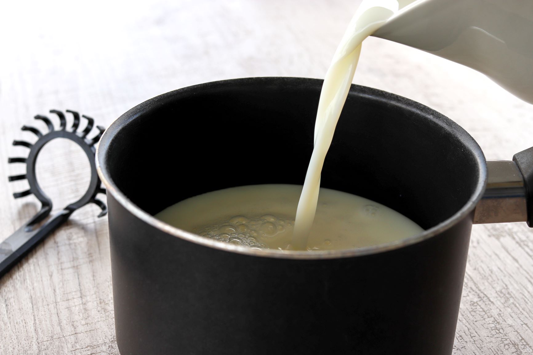 Maitoa kaadetaan pinnoitettuun kattilaan
