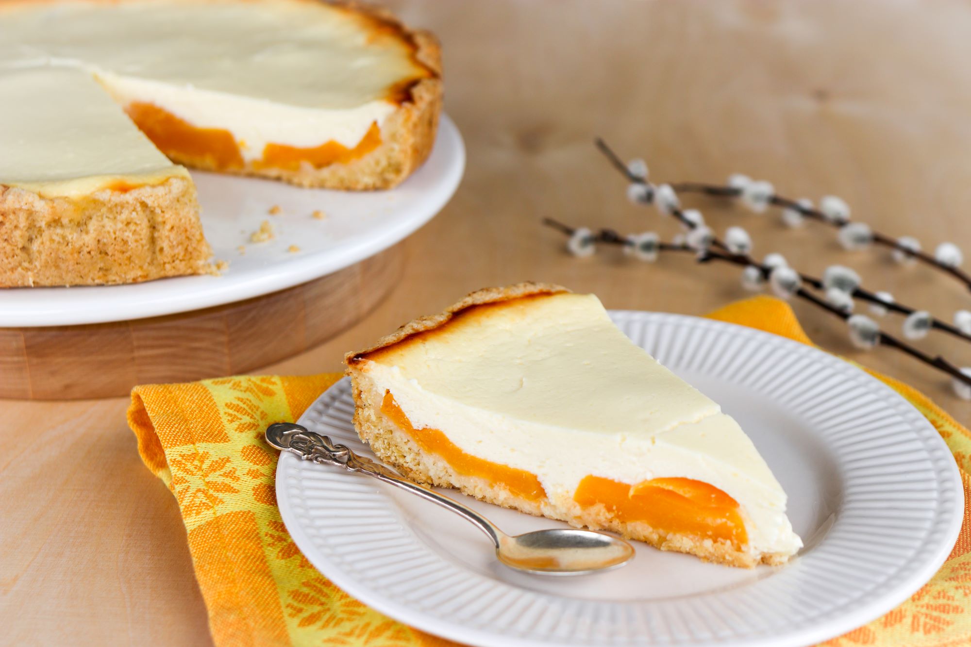 Pala gluteenitonta persikkapiirakkaa lautasella.