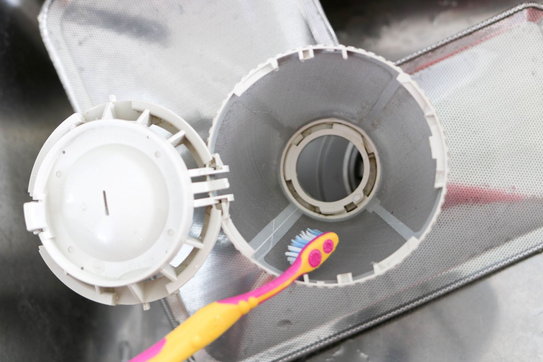 Vanha hammasharja poistosiivilän puhdistuksessa