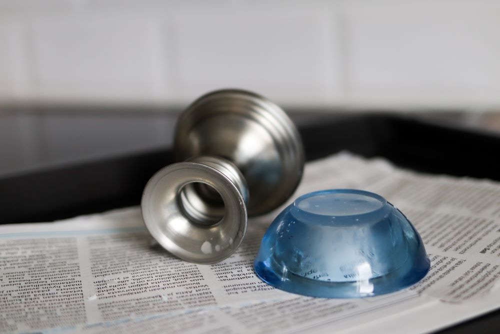 Kynttilänjalkoja sanomalehtipaperin päällä.