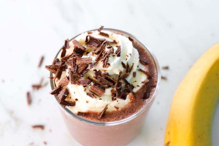 Banaani-suklaapirtelö kermavaahdolla koristeltuna