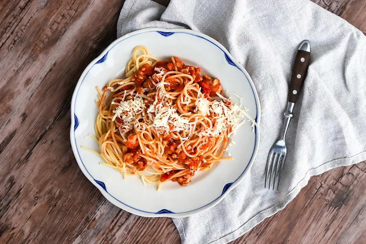 Broileribolognese höystetään juustoraasteella.