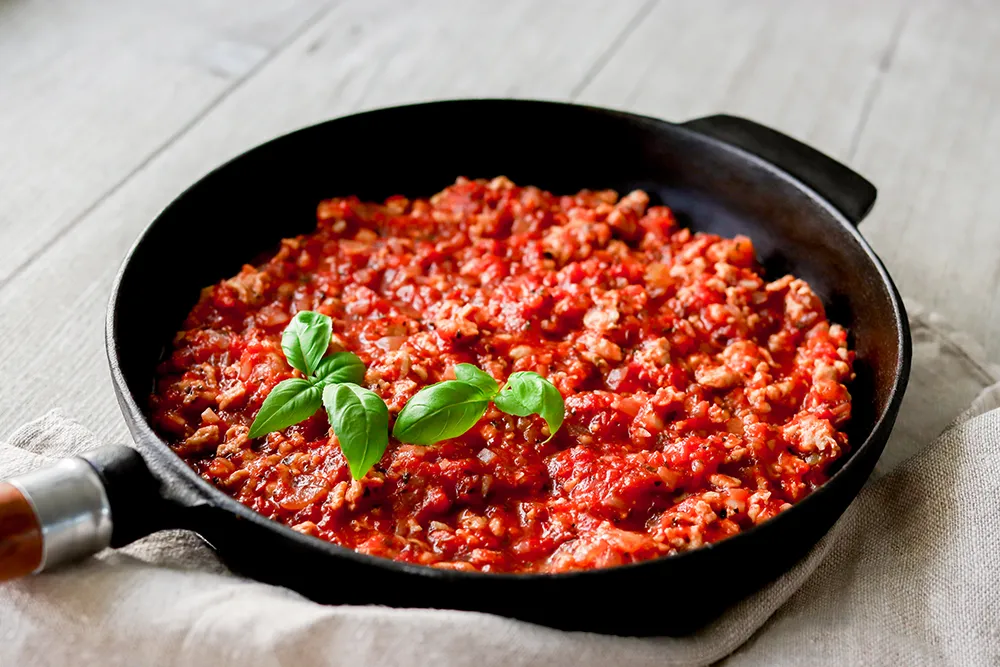 Broilerin jauhelihasta tehty kastike paistinpannulla.