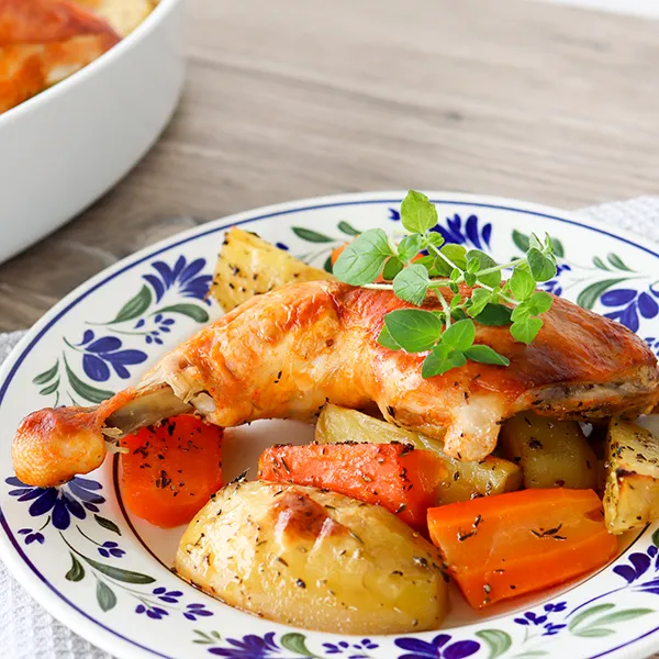 Broilerinkoivet perunoiden ja porkkanoiden päällä.