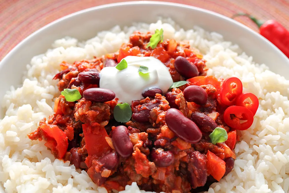 Chili con carne valkoisen riisin ja ranskankerman kanssa.