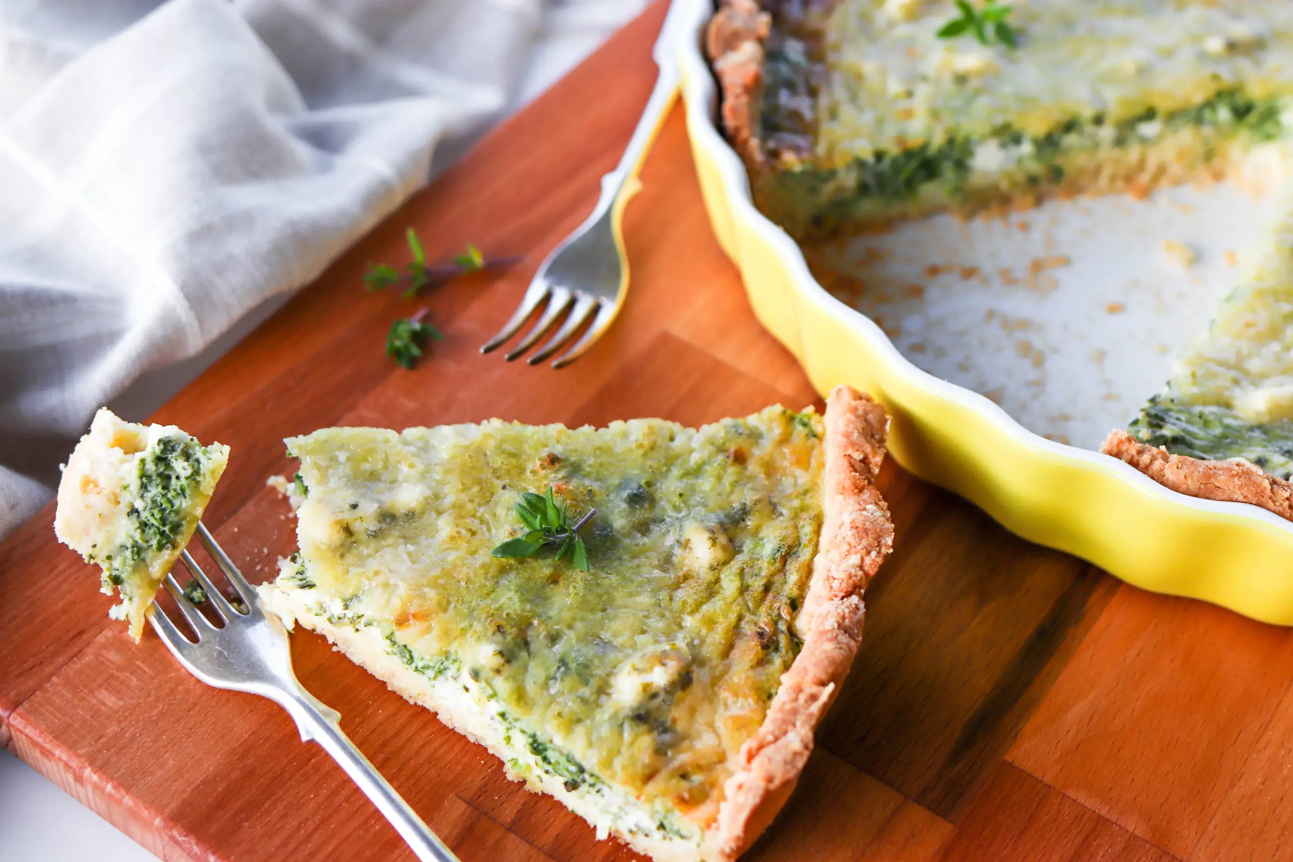 Gluteeniton feta-pinaattipiirakka, josta on otettu pala haarukalla.