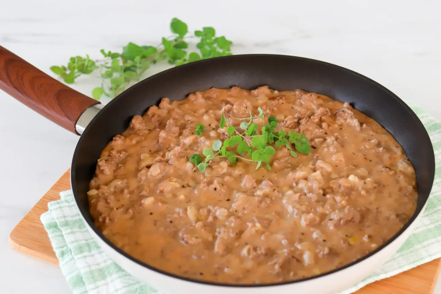 Gluteenitonta jauhelihakastiketta paistinpannulla oreganolla koristeltuna.