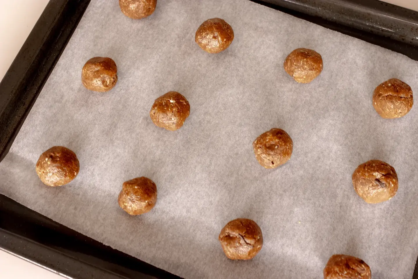 Gluteenittomat keksit pellillä leivinpaperin päällä ennen paistamista.