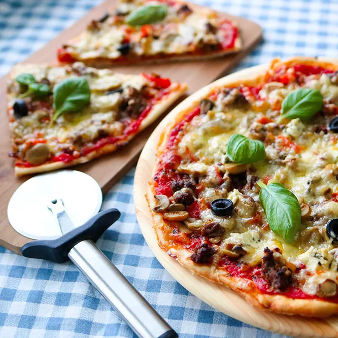 Pyöreä jauhelihapizza paloiksi leikattuna.