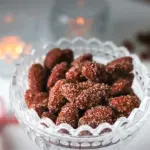 Kanelilla ja sokerilla kuorrutetut joulumantelit pienessä lasikulhossa.