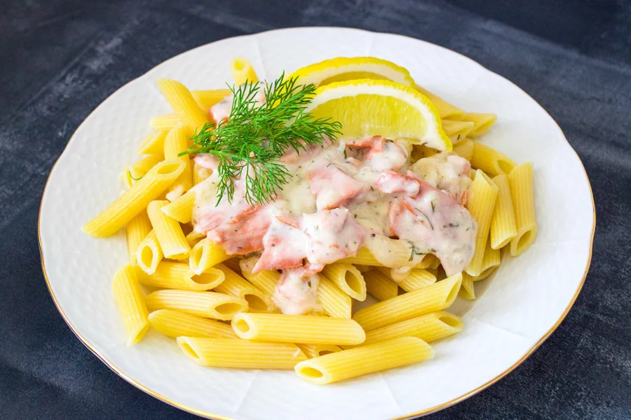 Kylmäsavulohipasta tuoreella tillillä ja sitruunalla koristeltuna.