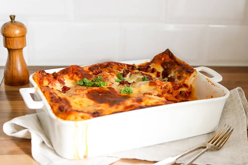 Lasagne keittiössä valkoisessa uunivuoassa.