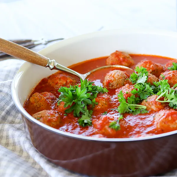 Lihapullat kypsyvät tomaattikastikkeessa.