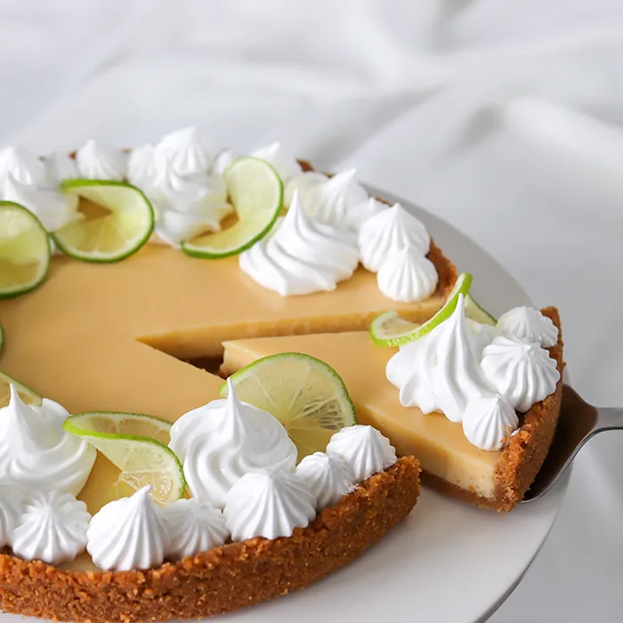 Limepiirakka, josta on leikattu pala kakkulapiolla.