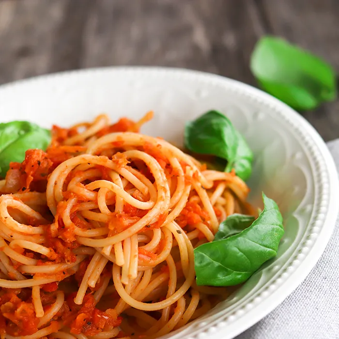 Linssibolognese lautasella tuoreen basilikan kanssa.