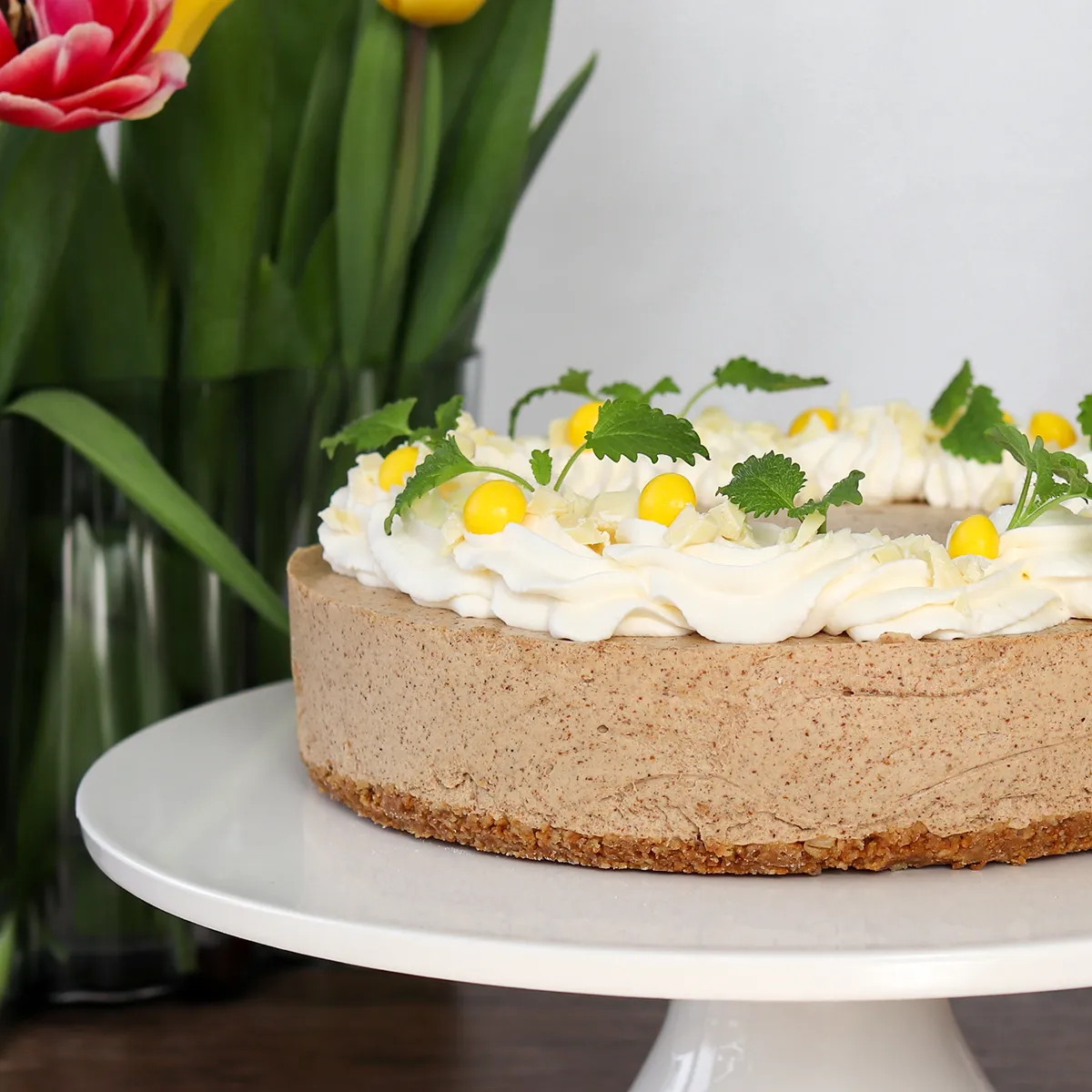 Mämmikakku kermapursotuksella ja makeisilla koristeltuna.