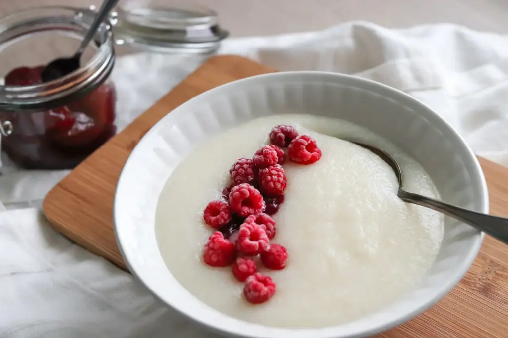 Maidoton mannapuuro lautasella marjojen ja hillon kera.