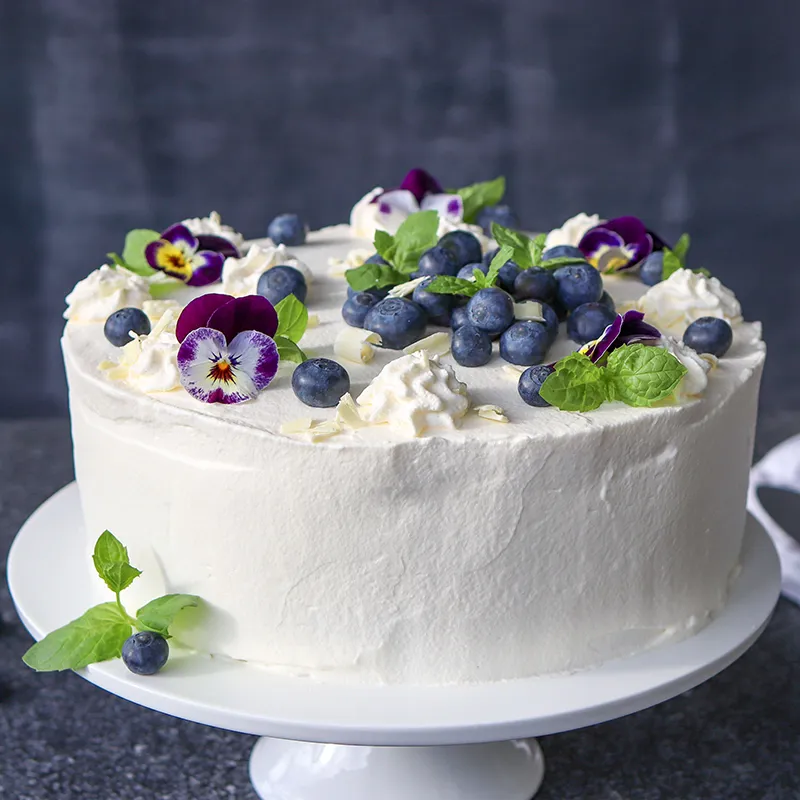 Mustikkakakku, jonka päällä on muun muassa valkosuklaata.