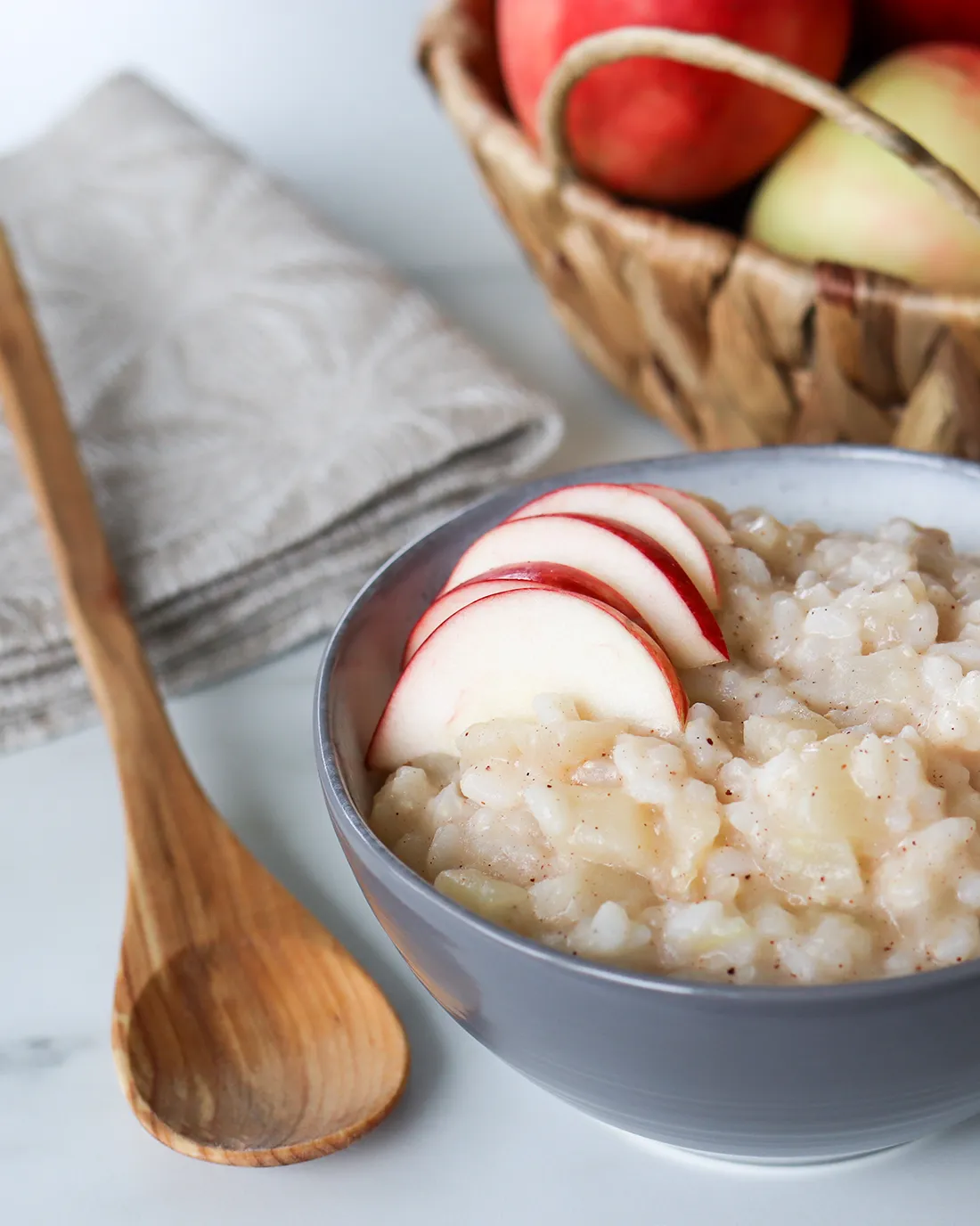 Omenariisipuuro kulhossa ja puinen lusikka.