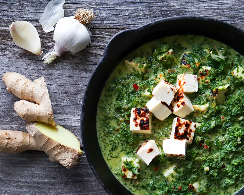 Palak paneer ja tuoretta inkivääriä ja valkosipulia.