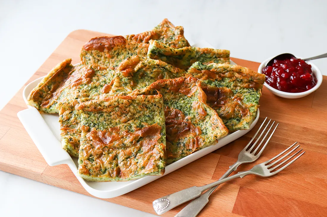 Pinaattipannukakku neliskulmaisiksi paloiksi leikattuna.