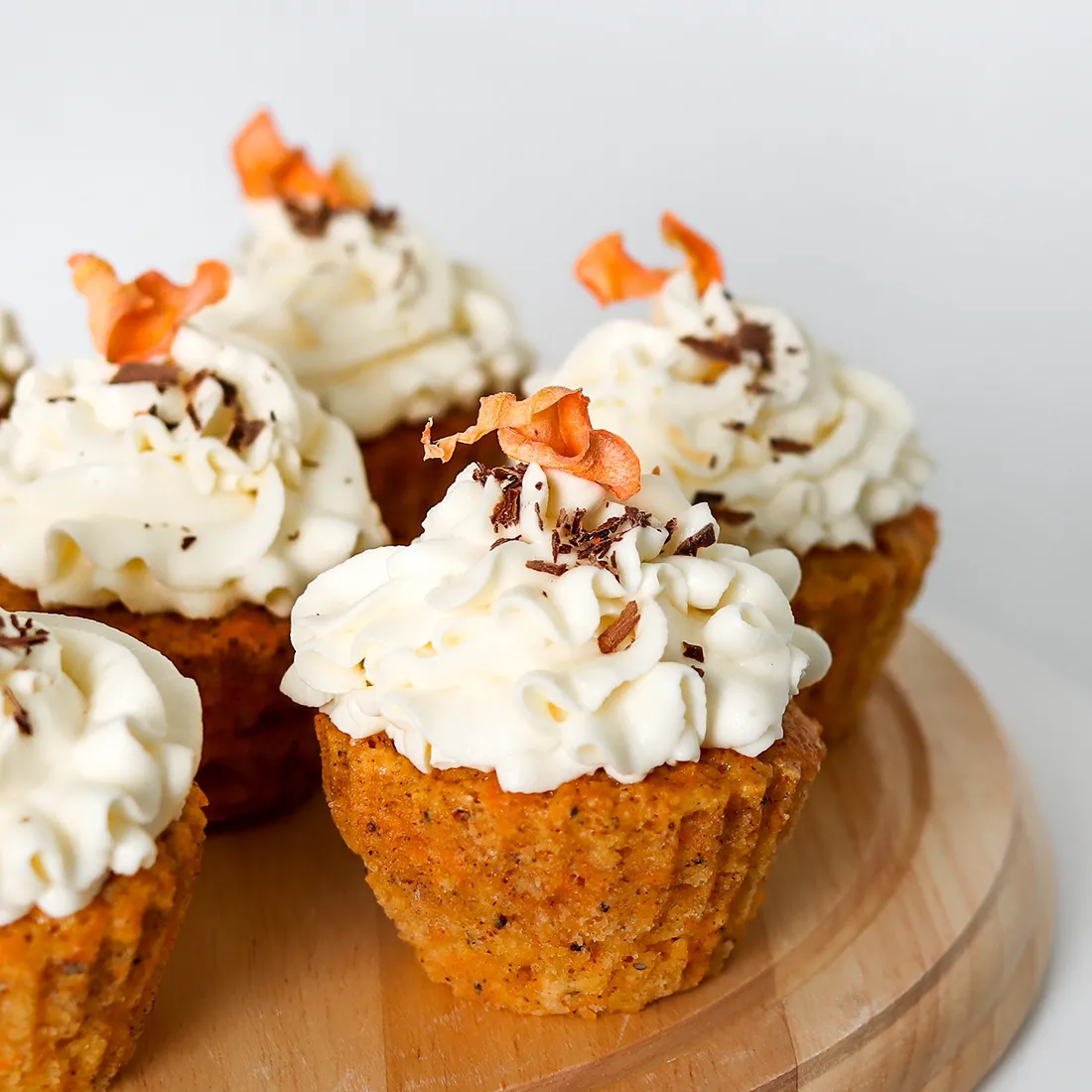 Porkkanamuffinssit, joiden päällä on kuorrutus ja koristeita.