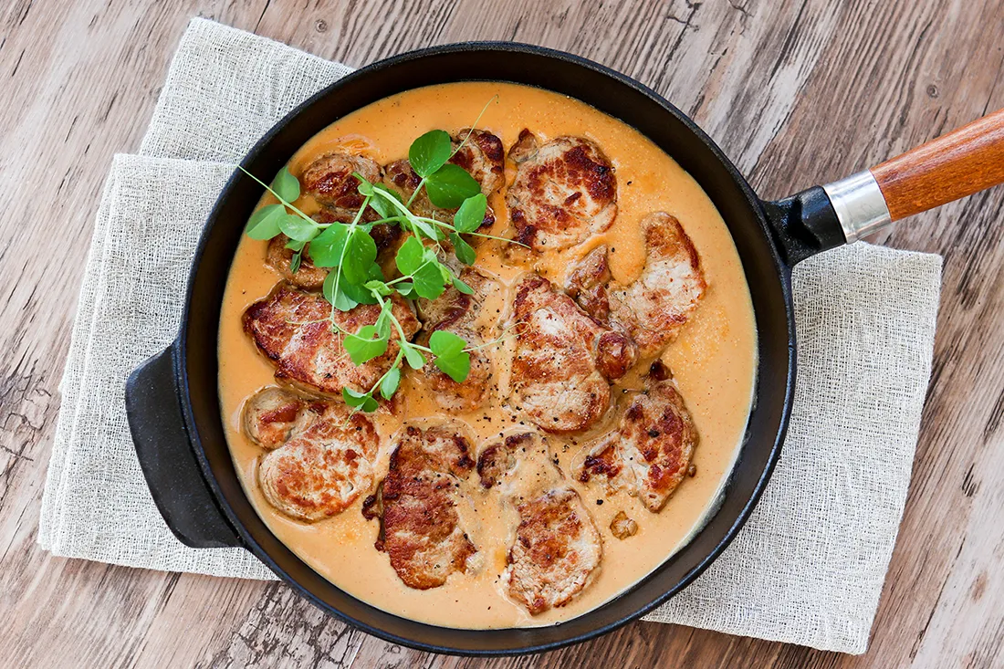 Possupihvit valurautapannulla vaaleanruskeassa kastikkeessa.