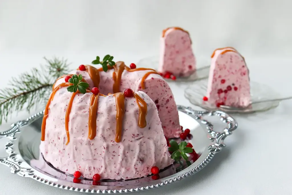 Puolukkajäädykettä kinuskikastikkeella koristeltuna.