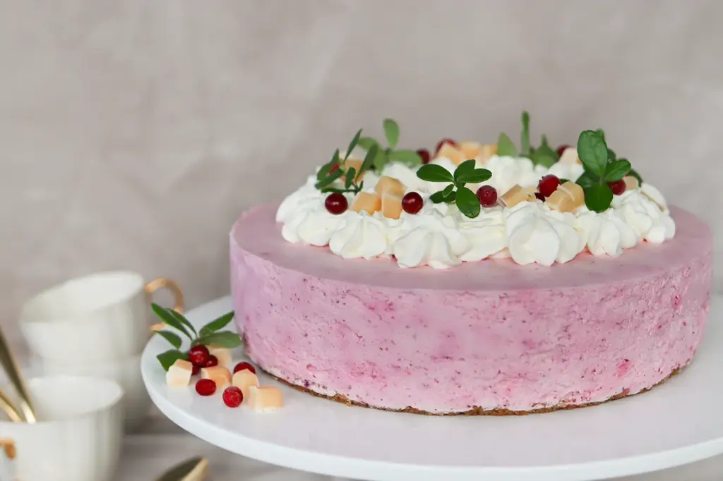 Puolukkajuustokakku kermavaahdolla ja toffeemakeisilla koristeltuna.