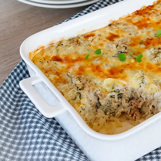 Riisi-tonnikalavuoka valkoisessa kahvallisessa uunivuoassa.