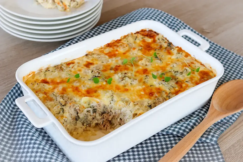 Riisi-tonnikalavuoka sinisävyisen liinan päällä vuoassa.