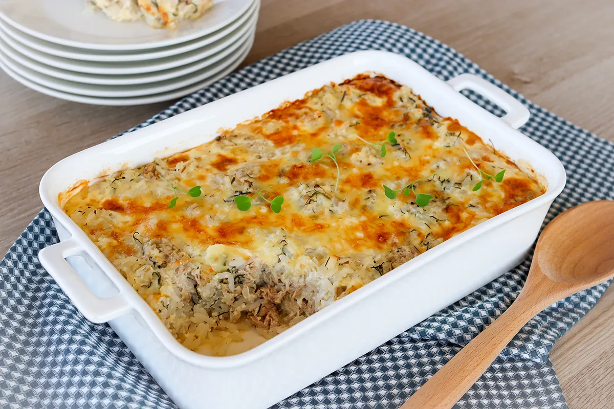 Riisi-tonnikalavuoka sinisävyisen liinan päällä vuoassa.