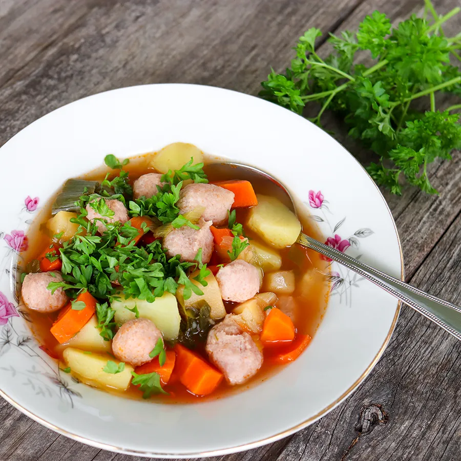 Siskonmakkarakeitto lautasella lusikan kanssa.