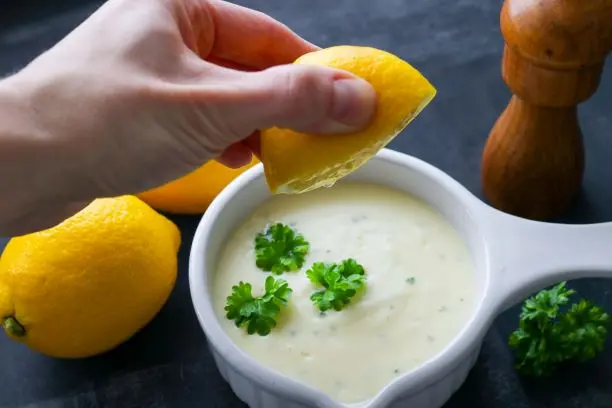 Sitruunakastike, johon puristetaan sitruunamehua.