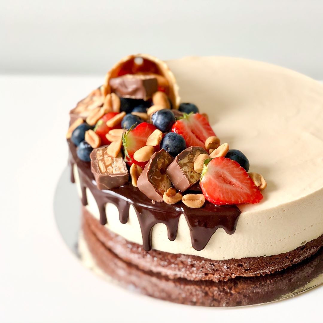 Snickers-kakun koristelu suklaalla ja marjoilla