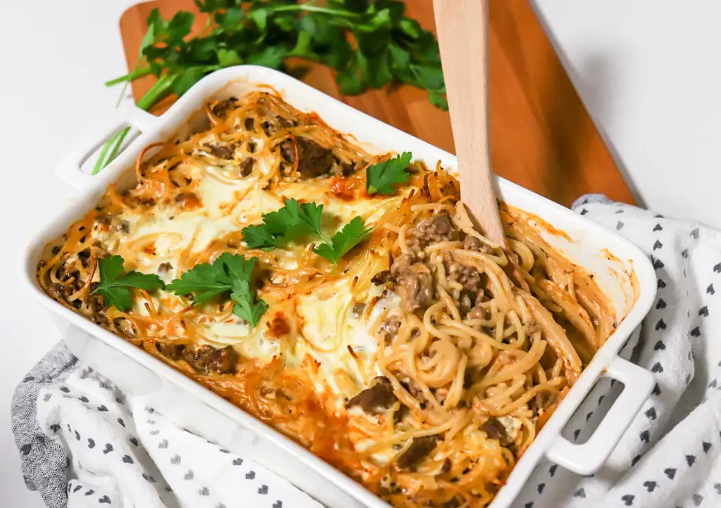 Spagetti-jauhelihavuoka lehtipersiljalla koristeltuna.