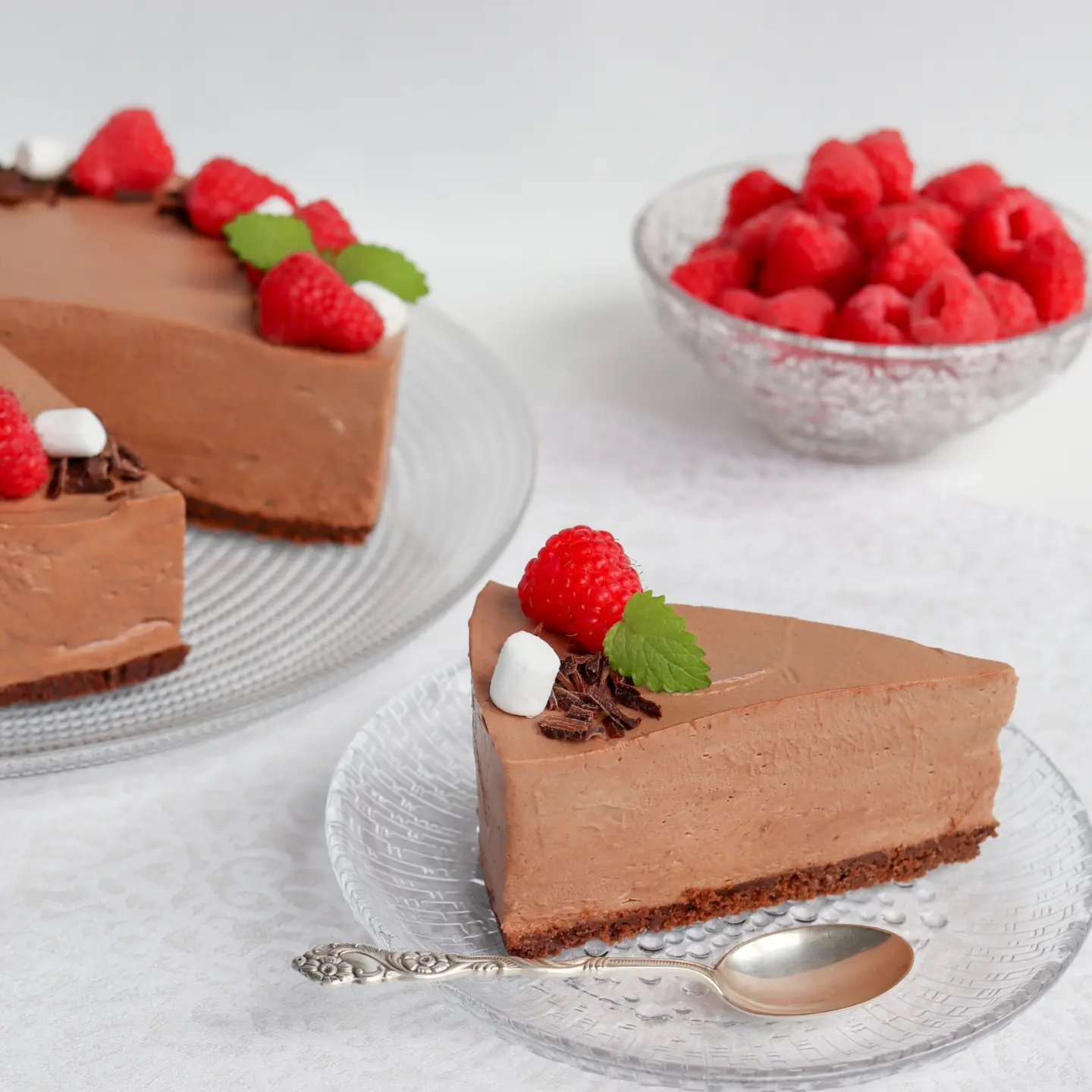 Gluteeniton suklaajuustokakku, josta on leikattu pala lautaselle.