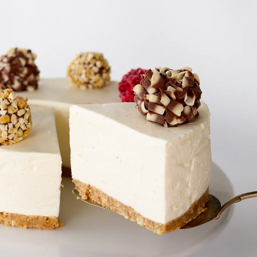 Vaniljajuustokakku, josta on leikattu pala kakkulapiolle.