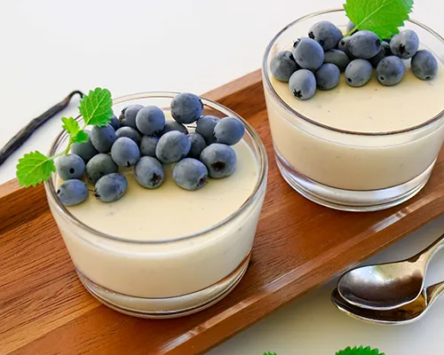 Vanilja-pannacotta kahdessa matalassa lasikulhossa.