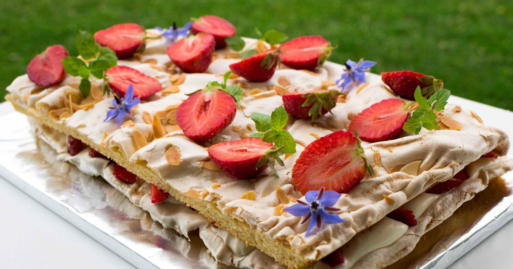 Britakakku mansikalla ja sitruunamelissalla koristeltuna.