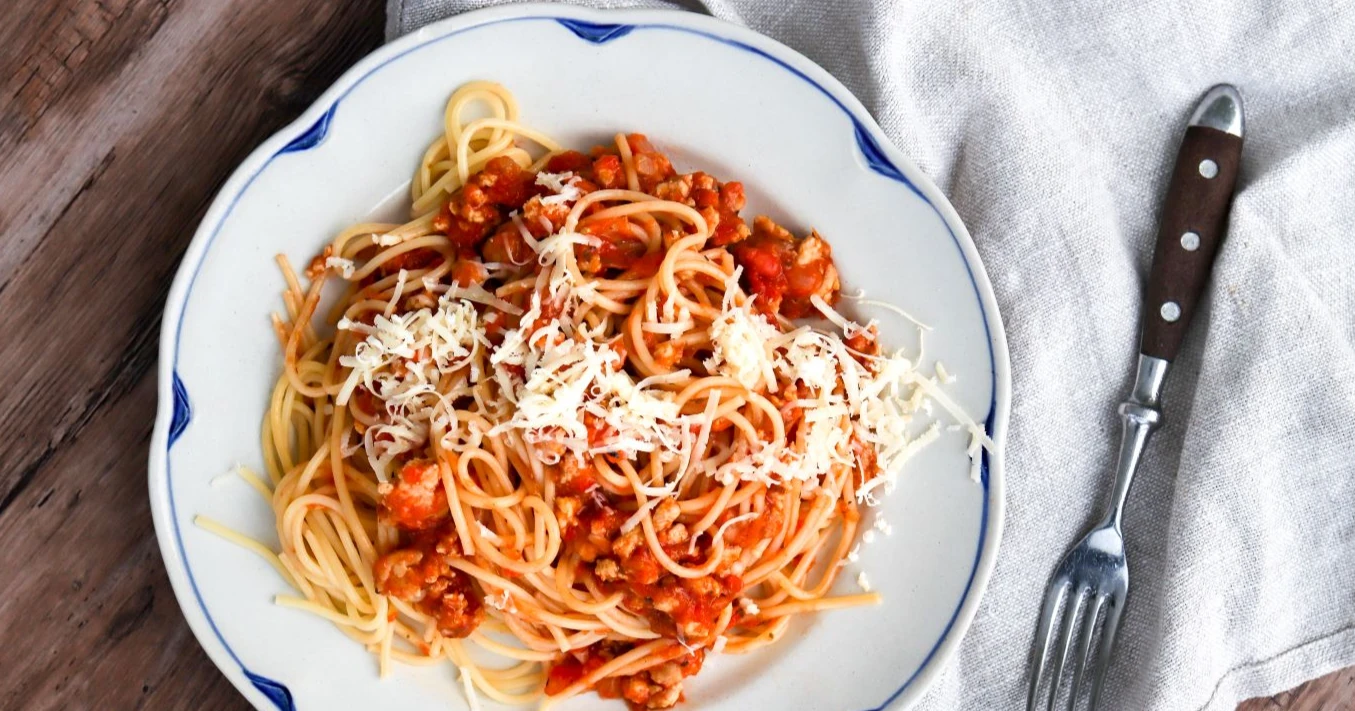 Broileribolognese höystetään juustoraasteella.