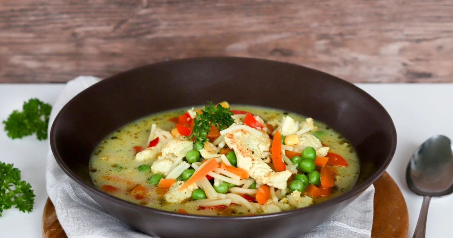 Broilerikeitto tummanruskealla syvällä lautasella.