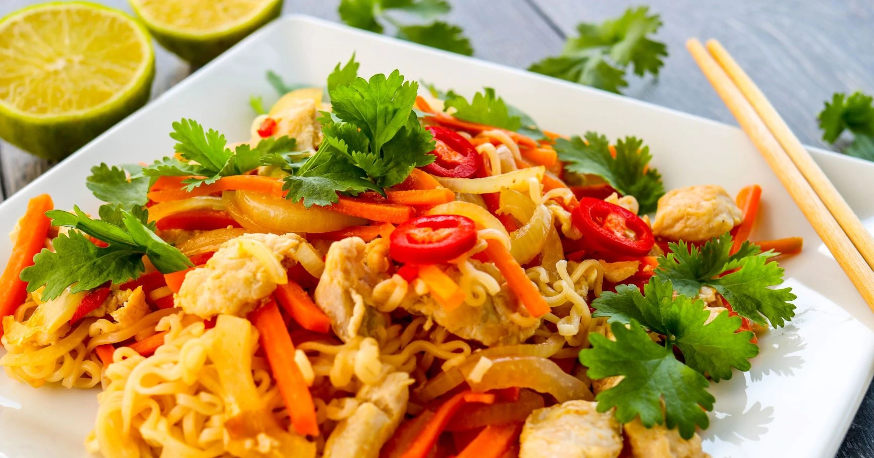 Broileri-nuudeliwokki, jonka päällä on chiliä ja tuoretta korianteria.