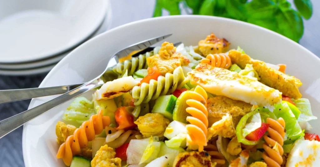 Broileri-pastasalaatti kulhossa halloumin kera.