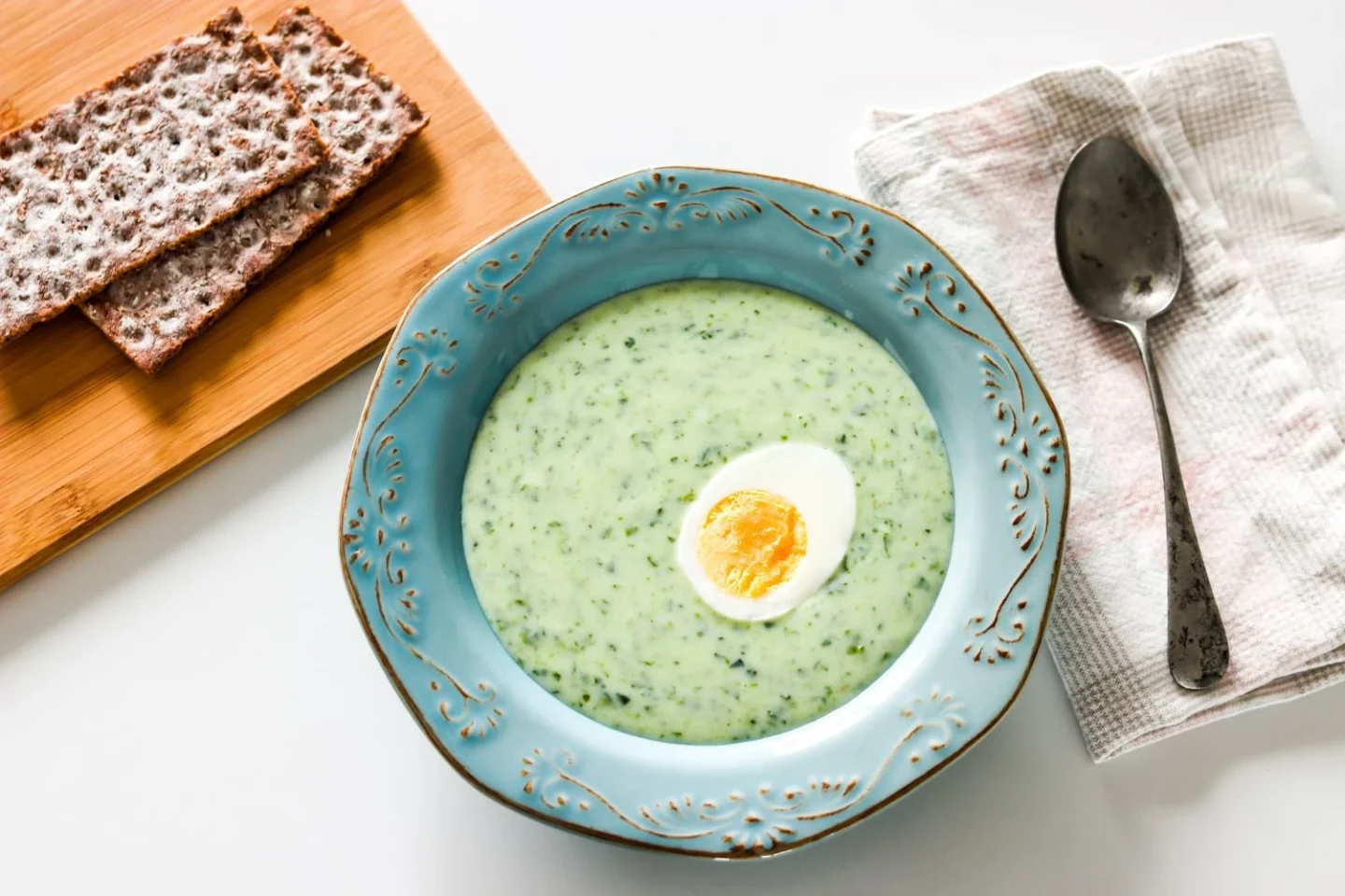 Gluteeniton pinaattikeitto lautasella puolikkaan keitetyn kananmunan kanssa.