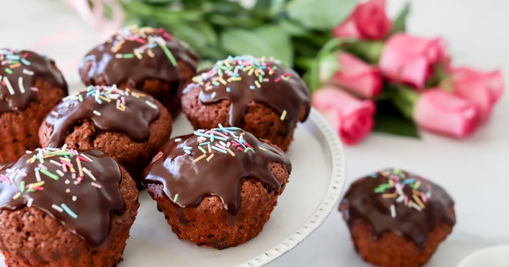 Gluteenittomat suklaamuffinssit suklaakuorrutuksella, jonka pinnalla on strösseleitä.