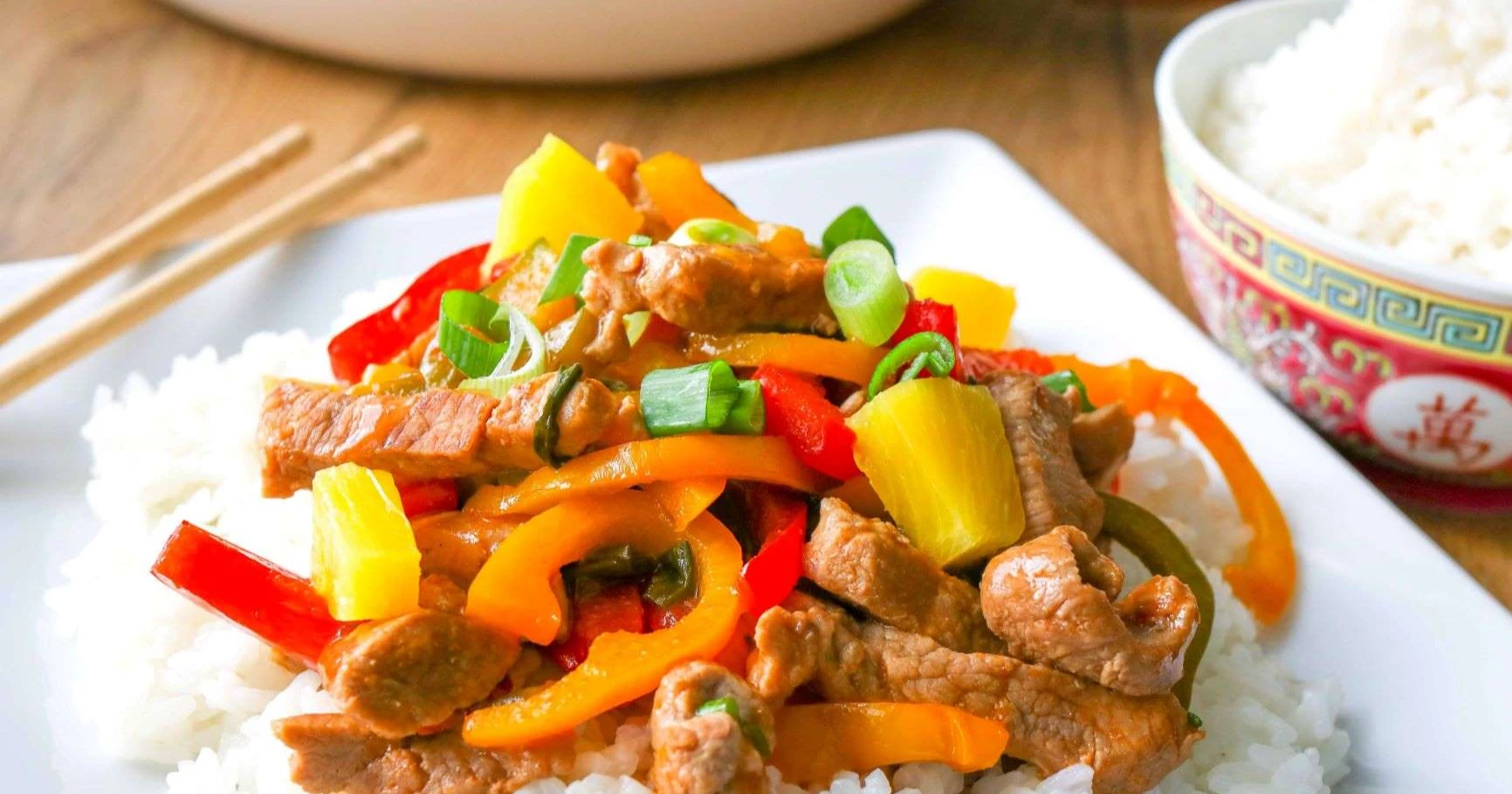 Hapanimelä possu neliskulmaisella valkoisella lautasella.