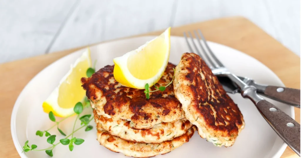 Haukipihvejä ja sitruunalohkoja valkoisella lautasella.