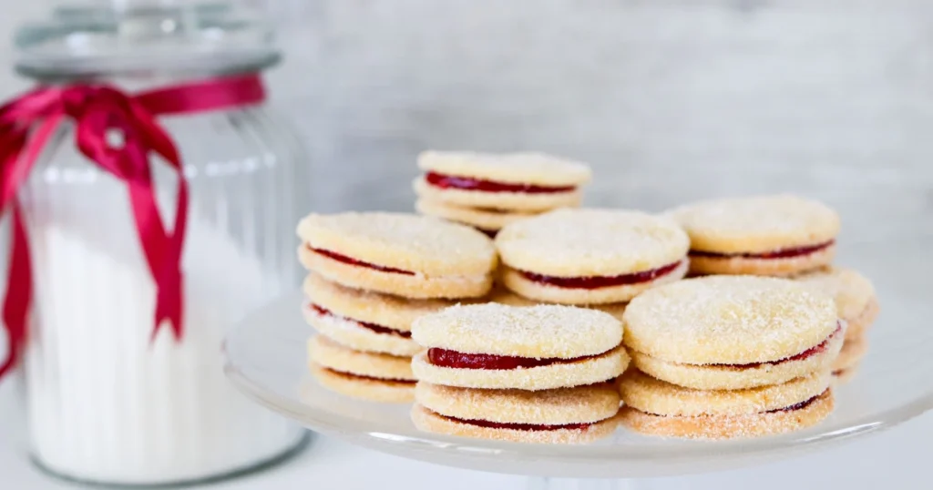 Herrasväen pikkuleipiä päällekkäin tarjoilulautasella.